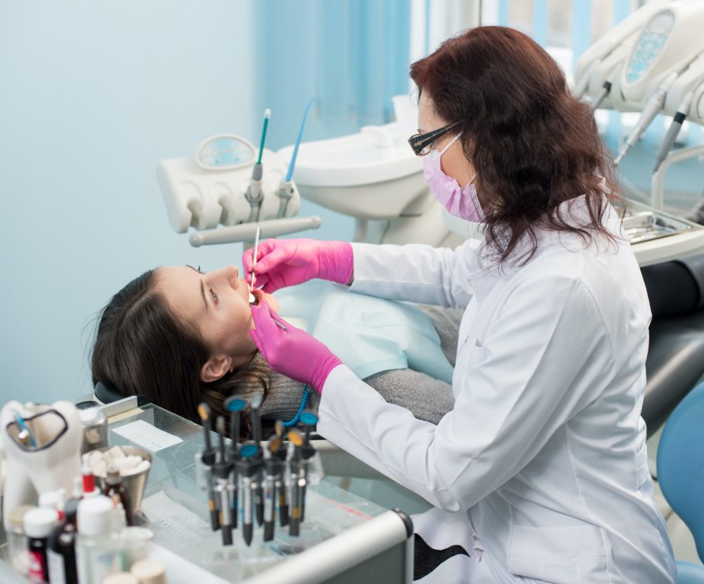 dentist with dental tools mirror and probe checking up patient teeth at dental clinic office 1 مجتبی صیدی دکتر دندان پزشک
